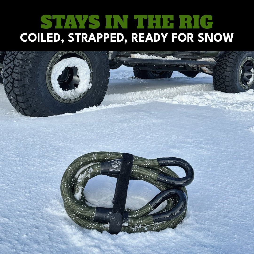 Stays in the rig: a Kinetic-X kinetic recovery rope coiled and strapped in the snow next to a Jeep