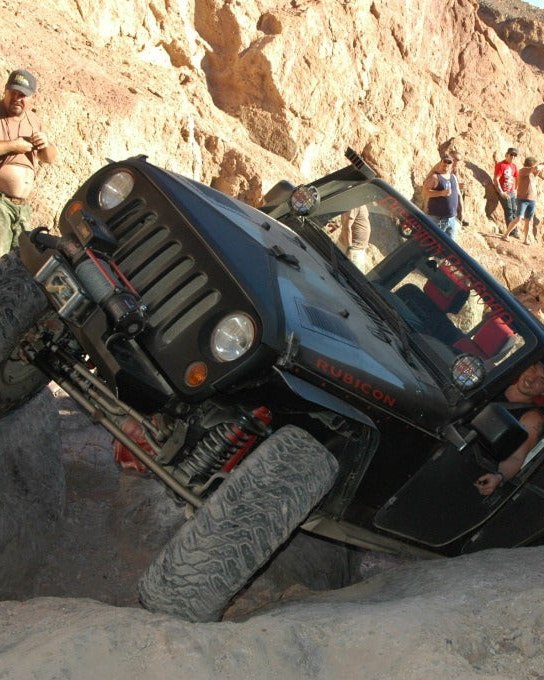Sandy Cats Jeep Wrangler crawling up a steep rock face